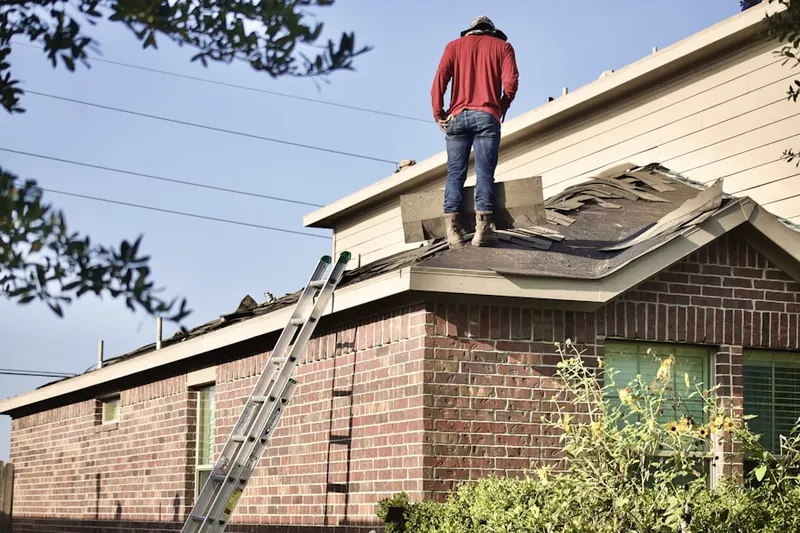 Professional roofer working on a residential roof in Broderick
